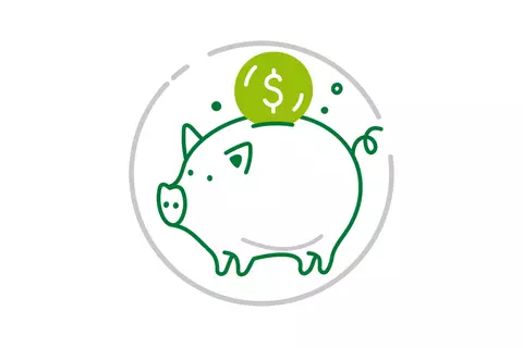 Eine Münze wird in ein Sparschwein gesteckt