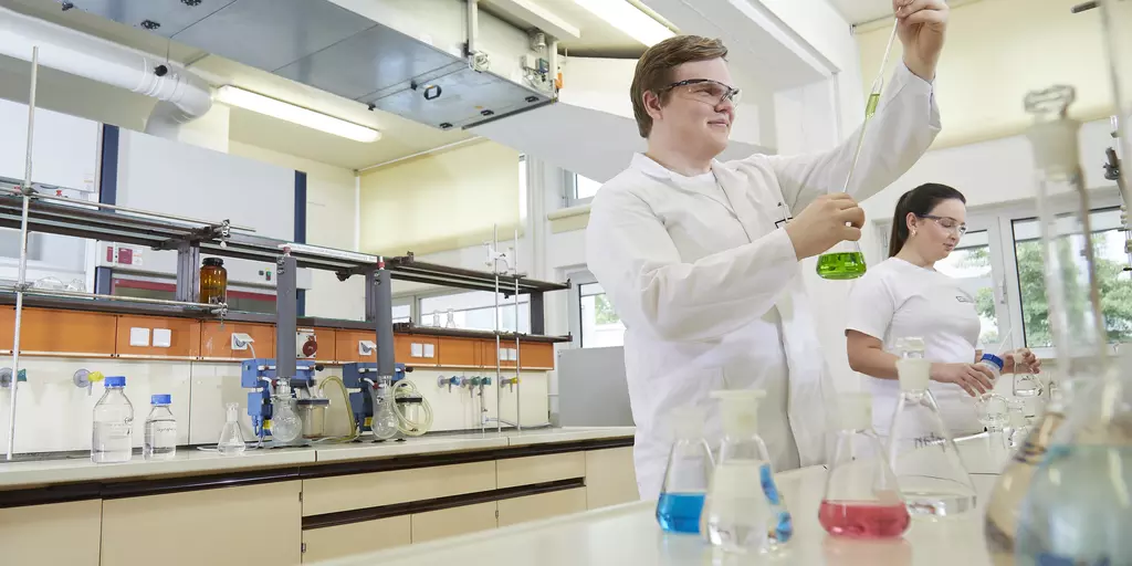 Ein Wissenschaftler füllt Flüssigkeit in ein Reagenzglas