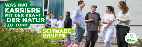 Gruppe an MItarbeitern steht auf dem Firmenhof und unterhält sich